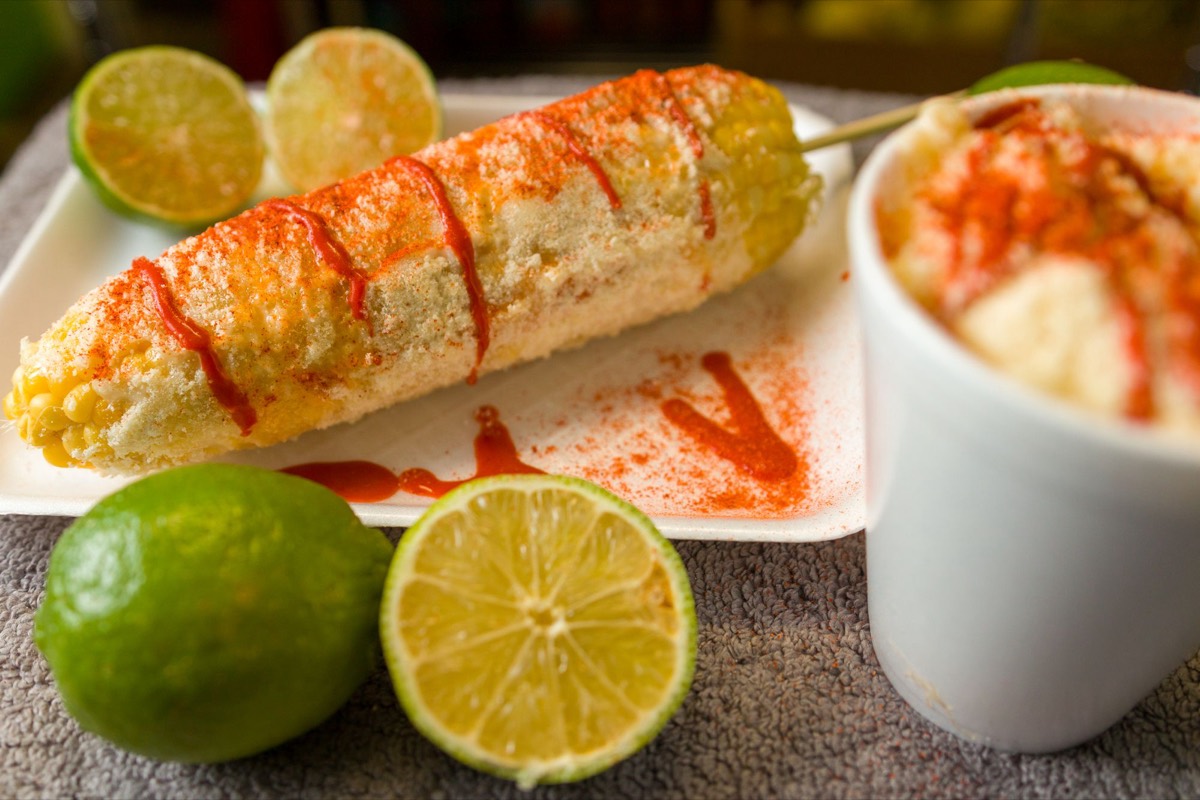 Street-style elote in a cup with lime